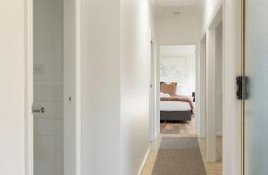 a hallway with a bathroom with a bed in a bedroom at Hamptons on the Bay in Swansea +71 photos