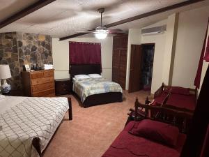 a bedroom with two beds and a ceiling fan at Quinta Las Victorias in Valle de Anton