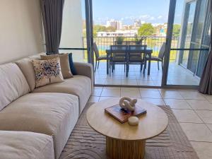 a living room with a couch and a table at Tranquil 3 Bedroom Retreat in Townsville City in Townsville