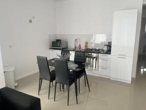 a dining room with a table and chairs in a kitchen at Casa Miranda in Mindelo