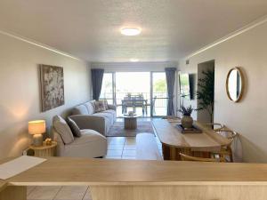 a living room with a couch and a table at Tranquil 3 Bedroom Retreat in Townsville City in Townsville