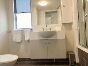 a white bathroom with a sink and a toilet at Tranquil 3 Bedroom Retreat in Townsville City in Townsville +29 photos