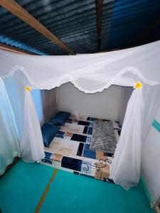 a bed in a room with a white canopy at Jhuna Komodo Homestay in Komodo +193 photos