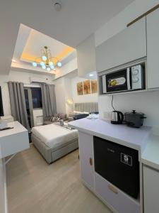 a kitchen and living room with a bed in a room at Azzure North Pampanga Cloudline Suite 418 Barbados in San Fernando