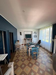 a living room with a table and chairs and a television at Maison de Georges et Paulette in Bouesse