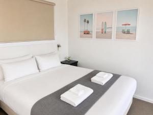 a bedroom with a large white bed with two towels at BIG4 Robe Lakeside Tourist Park in Robe