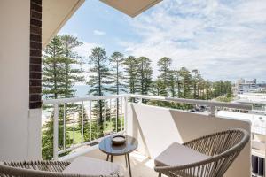 a balcony with two chairs and a table at Stunning Beachfront penthouse-Beach District Views in Sydney