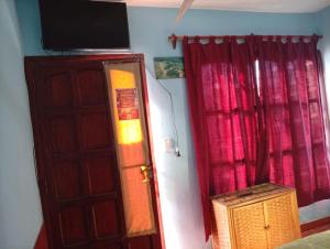 a room with a door and a television on top at Hostal Mechita Mamani in Cafayate