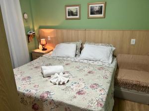 a bed with two pillows and a bow on it at Piemonte Flat 104 B in Serra Negra +43 photos
