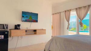 a bedroom with a bed and a television on a wall at Old Harbour Oasis in Old Harbour