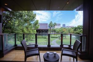 a balcony with chairs and a table and a large window at DoubleTree By Hilton Jiaxing in Jiaxing