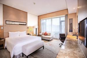 a hotel room with a large bed and a television at DoubleTree By Hilton Jiaxing in Jiaxing