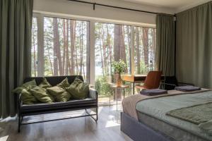 a bedroom with a couch and a large window at Gauja Lakeside in Gauja