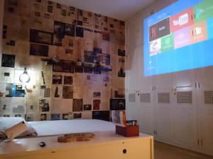 a room with a projection screen and a bed at Fenergia Hospedagem Flexível in Pouso Alegre