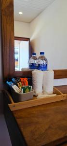 a shelf with toilet paper and two bottles of water at French garden Pragash Beach Hotel in Trincomalee