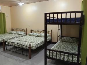 a room with three bunk beds in it at Bahay Domingo Guesthouse & Private Pool in Bagac +11 photos
