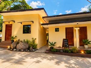 a house with a sign in front of it at Bahay Domingo Guesthouse & Private Pool in Bagac