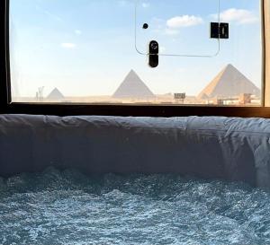 a window with a view of pyramids in the background at Aura Grand pyramids view inn in Giza