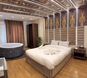 a bedroom with a large bed and a bath tub at Aura Grand pyramids view inn in Giza +37 photos