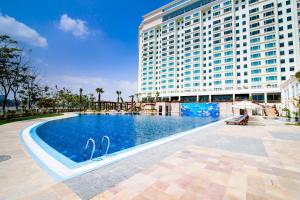 a swimming pool in front of a large building at Sokha Phnom Penh Residence in Phnom Penh