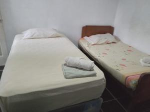 two twin beds in a room with towels on them at Hostel Casa María in Masaya