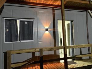 a house with a window and a light on a porch at Contêineres em Bombinhas in Bombinhas