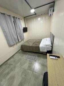a room with a bed and a table in it at Contêineres em Bombinhas in Bombinhas