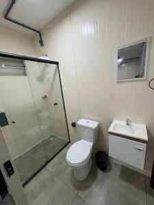a bathroom with a shower and a toilet and a sink at Contêineres em Bombinhas in Bombinhas