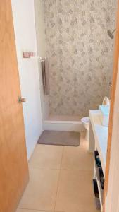 a bathroom with a shower with a toilet and a sink at Old Harbour Oasis in Old Harbour