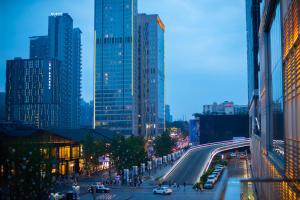 a busy city street with cars on a road with tall buildings at Niccolo Chengdu in Chengdu