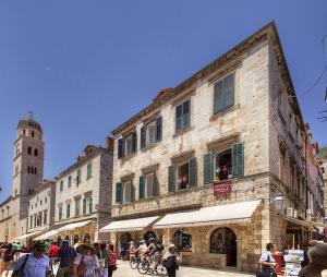 a group of people walking on a street in front of a building at Palmotta Palace in Dubrovnik