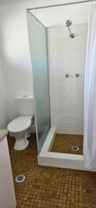 a bathroom with a toilet and a glass shower at Port O'Call Motel in Port Macquarie +23 photos