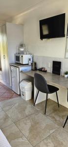 a kitchen with a table and a chair and a microwave at Port O'Call Motel in Port Macquarie