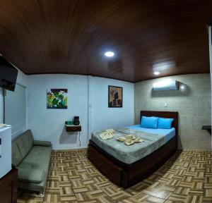 a bedroom with a bed and a couch in it at Tortuguero7 lake view in Tortuguero