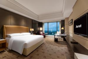 a hotel room with a bed and a flat screen tv at Zhuzhou Marriott Hotel in Zhuzhou