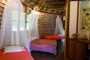 a room with two beds and mosquito nets at 3 Cozy TripleDouble Rooms - Trisquel in Restrepo