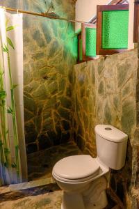 a bathroom with a toilet and a stone wall at 3 Cozy TripleDouble Rooms - Trisquel in Restrepo +75 photos