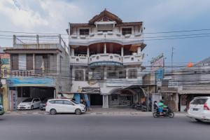 a tall building with cars parked in front of it at Bojongsoang Guesthouse RedPartner in Bandung