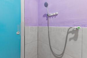 a shower with a shower head on a wall at Bojongsoang Guesthouse RedPartner in Bandung +17 photos