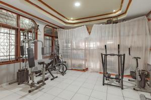 a gym with bikes and exercise equipment in a room at Bojongsoang Guesthouse RedPartner in Bandung