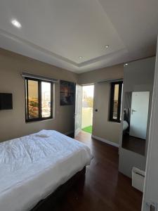 a bedroom with a large white bed and windows at Pcg Homes in Lagos