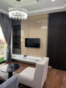 a living room with a television and a table and chairs at Pcg Homes in Lagos +7 photos