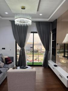 a living room with a chandelier and a large window at Pcg Homes in Lagos
