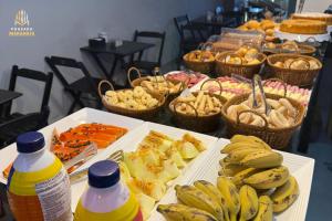 a buffet of food with bananas and baskets of bread at Pousada Maranata in Aparecida