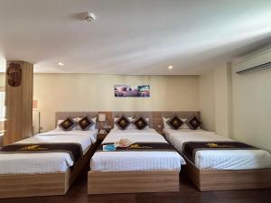 a room with three beds in a room at Sen Vàng Luxury Hotel in Nha Trang