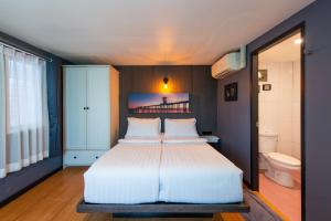 a bedroom with a large bed and a bathroom at BB House Phra Athit บีบี เฮ้าส์ พระอาทิตย์ in Bangkok