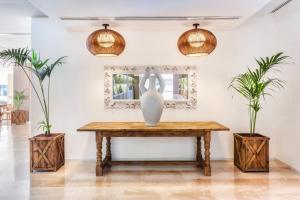 a vase on a table in a room with two plants at Meliá Calviá Beach in Magaluf +105 photos