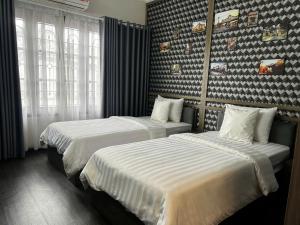 two beds in a hotel room with two beds at Hanoi Lucky Hotel in Hanoi