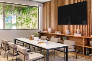 a dining room with a table and chairs and a tv at Meliá South Beach in Magaluf
