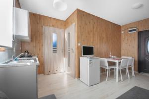 uma cozinha com um frigorífico branco e uma mesa com cadeiras em Cuma Camp em Sarbinowo